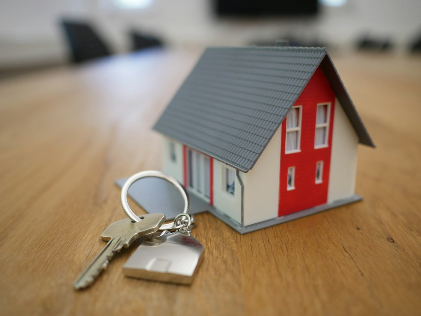House keys on a ring beside a small model home